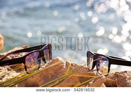 Two Sung Lasses Lie On A Stone Against The Background Of The Sea