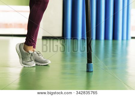 Legs Of Young Fit Woman Doing Exercise With Bodybar In Gym