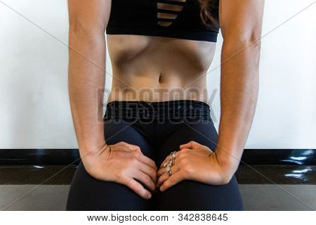 Stomach Of A Skinny Yoga Instructor As She Sits On Her Knees In A Resting Pose And Breathes In Showi