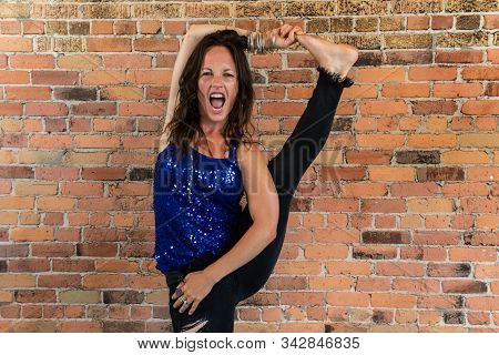 A Flexible Yogic Instructor Flaunts Her Skills During A Yoga Class, With Wide Opened Mouth As She Ra