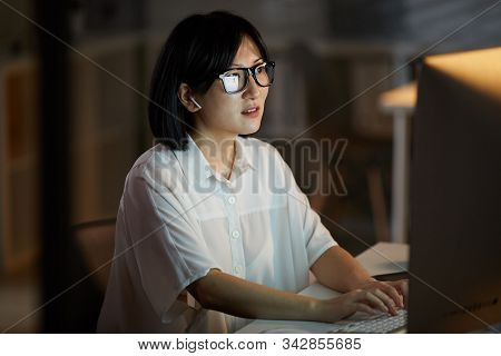 Serious Asian Businesswoman Wearing Eyeglasses Looking At Computer Monitor And Typing She Working Ti
