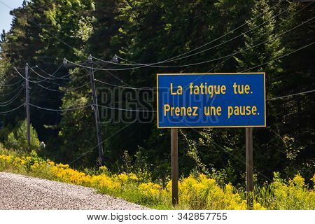 Blue Information Road Sign With French Yellow Writing, Tiredness Kills. Take A Break., On Rural Coun