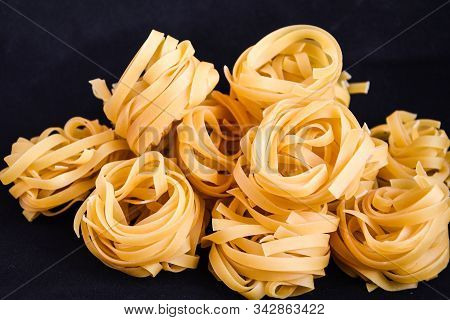 Pasta Alluovo, Tagliatelle Pasta, Round Balls Of Raw Pasta On Black Background, Close Up Of A Raw Dr