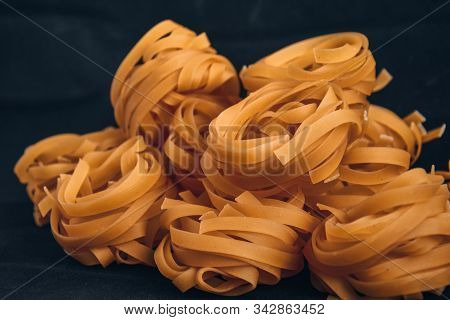 Pasta Alluovo, Tagliatelle Pasta, Round Balls Of Raw Pasta On Black Background, Close Up Of A Raw Dr