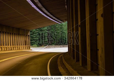 Curve Tunnel For Automobiles, Exit At Backgorund. Empty Engineering Construction With Rhythm Of Ligh