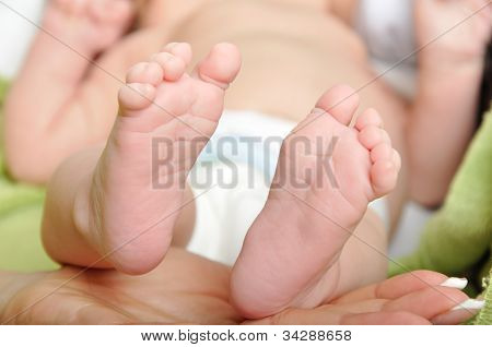 Pés de bebê na mão da mamãe