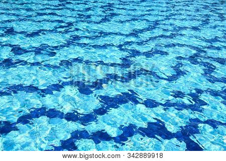 The Water Surface Of The Swimming Pool Turquoise Color, Illuminated By The Sun