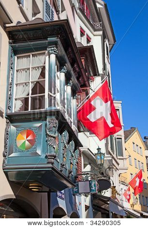 Gamle gade Augustinergasse i Zürich dekoreret med schweiziske flag