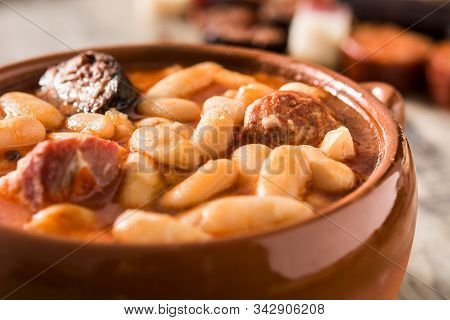 Typical Spanish Fabada Asturiana On Wooden Table
