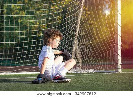 Childrens Soccer Football - A Match Of Young Children On The Football Field. Thoughtful Little Boy S