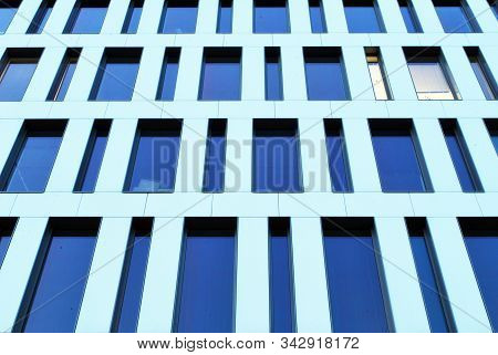 Geometric Reflection: Partly Cloudy Sky Reflected By Window Panes Of Office Building. Surface Of Gla