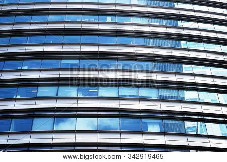 Geometric Reflection: Partly Cloudy Sky Reflected By Window Panes Of Office Building. Surface Of Gla