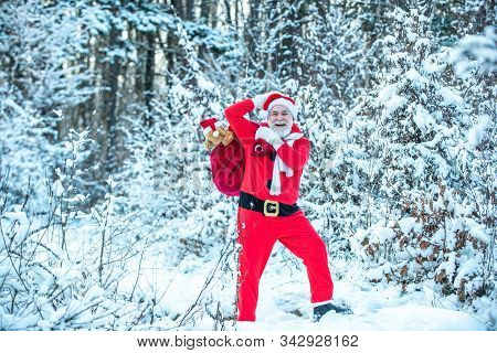 Santa In The Winter Field. Merry Christmas And Happy New Year. Santa In Red Suit Walking Along The R