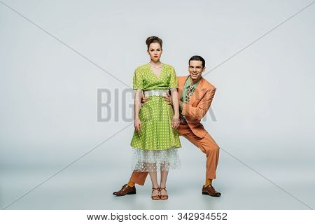 Stylish Dancers Looking At Camera While Dancing Boogie-woogie On Grey Background