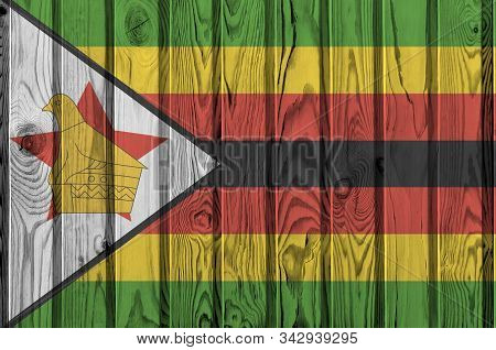 Zimbabwe Flag Depicted In Bright Paint Colors On Old Wooden Wall. Textured Banner On Rough Backgroun