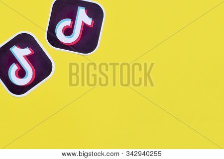Tiktok Paper Logo On Yellow Background. Tiktok Is A Popular Video-sharing Social Networking Service 