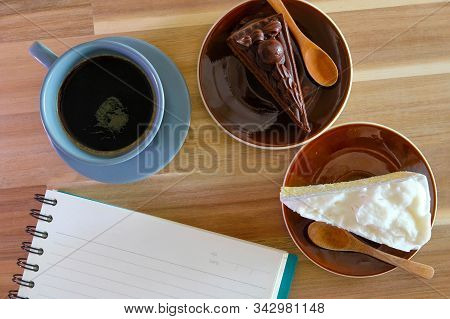 Notebook, Coffee, Chocolate Cake And Coconut Cake On Wooden Background