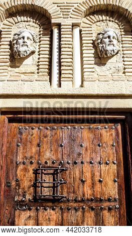 Old And Majestic Facade With Carved Stone Sculptures And Old Wooden Door In Polop Village, Alicante,