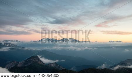 Glow On Slope Of Mountain Ridge Lit By Setting Sun In Scenic Valley With Cloud Sky