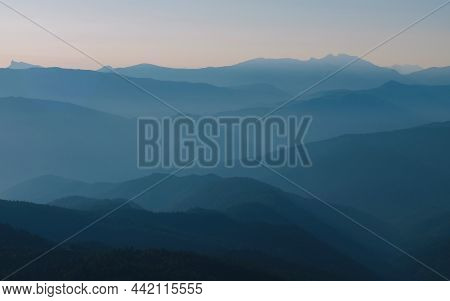 Mountain silhouette layers in the sunset light. Beautiful photography of the nature, blue layered background. Natural gradient.