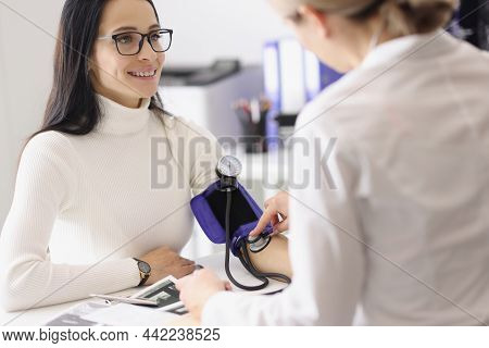 Portrait Of Doctor Measuring Patients Blood Pressure With Tonometer Tool And Talk. Planned Checkup A