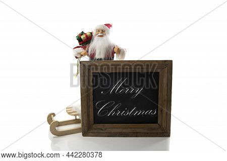 Santa Claus With Blackboar And The Text Merry Chrismas Isolated On White Background