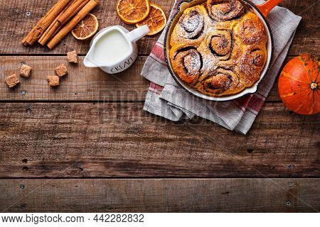 Cinnabon Cinnamon Rolls Buns With Pumpkin, Nut, Caramel And Sugar Cream Iced On Rustic Wooden Backgr