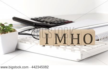 Imho Written On Wooden Cube On Keyboard With Office Tools