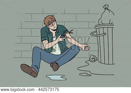 Drug Addict And Narcomaniac Concept. Young Man Drug Addict Sitting On Floor Putting Syringe With Her