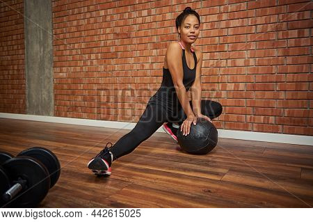 Attractive Young African American Female Athlete In A Stylish Tight-fitting Tracksuit Performing Sid