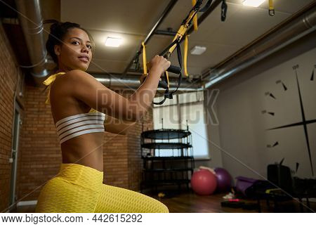 Side Portrait Of An Attractive Sporty Woman Doing Glute Exercises, Performing Side Lunges And Squats