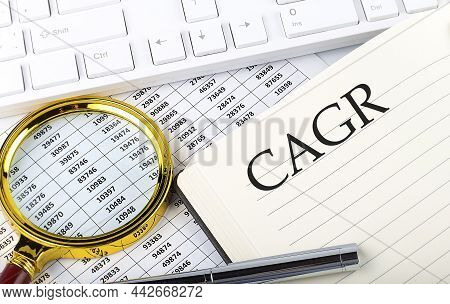 Compound Annual Growth Rate Cagr Text On The Notebook With Chart, Magnifier,keyboard And Pen