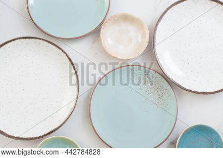 Assorted Ceramic Plates On White Marble Table