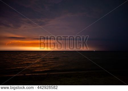 Lightning Bolts Illuminate The Sky At Night In The Sea
