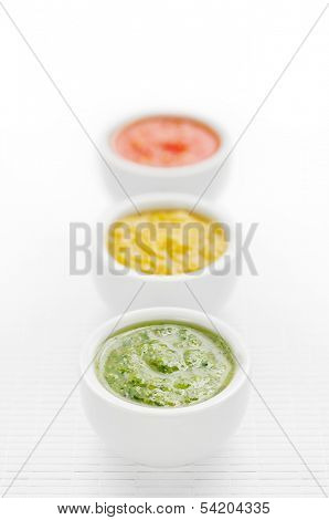 Three green, yellow and red sauces in a row