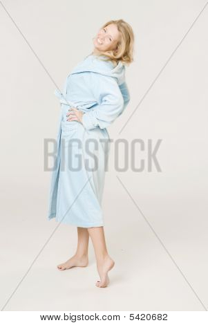 Eine Mädchen ist In Badehaus-Morgenmantel Blau gekleidet.