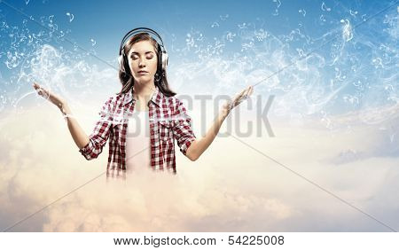 Image of young pretty woman with headphones meditating