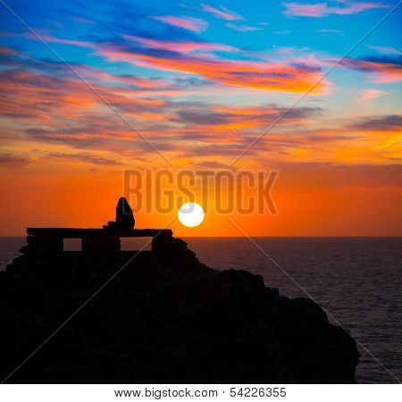 Ciutadella Menorca at Punta Nati orange sunset with girl backlight