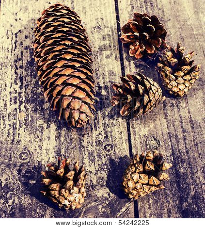 Pile of brown pine cones on wooden table for backgrounds or textures