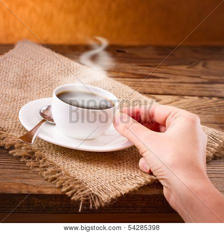 Coffee cup and saucer on  wooden table.