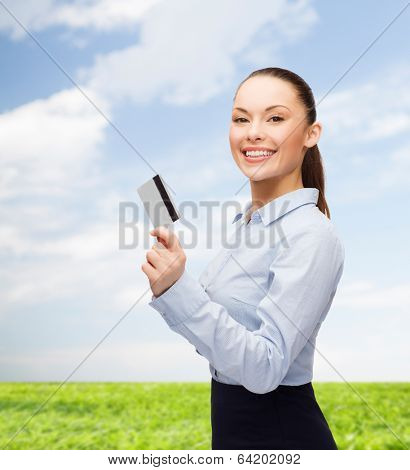 business and bank concept - smiling businesswoman showing credit card