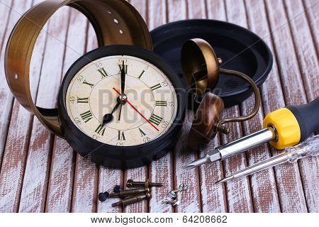 Repair clock on wooden background