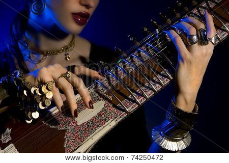 Beautiful Young Indian Woman In Traditional Clothing With Oriental Jewelry Playing The Sitar