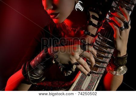 Beautiful Young Indian Woman In Traditional Clothing With Oriental Jewelry Playing The Sitar