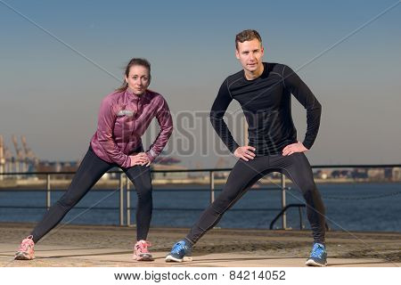 Young Couple Exercising At The Waterfront