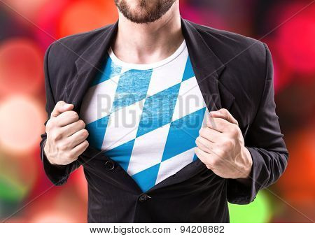 Businessman stretching suit with Bavarian Flag on bokeh background