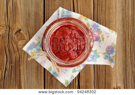 Homemade Strawberry Jam In Open Glass Jar With Hempstring On Paper Napkin