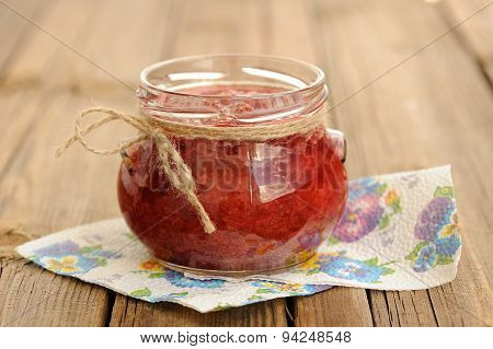 Homemade Strawberry Jam In Open Glass Jar With Hempstring On Paper Napkin