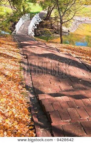 Herbstlandschaft mit Treppen, Brücke und Teich