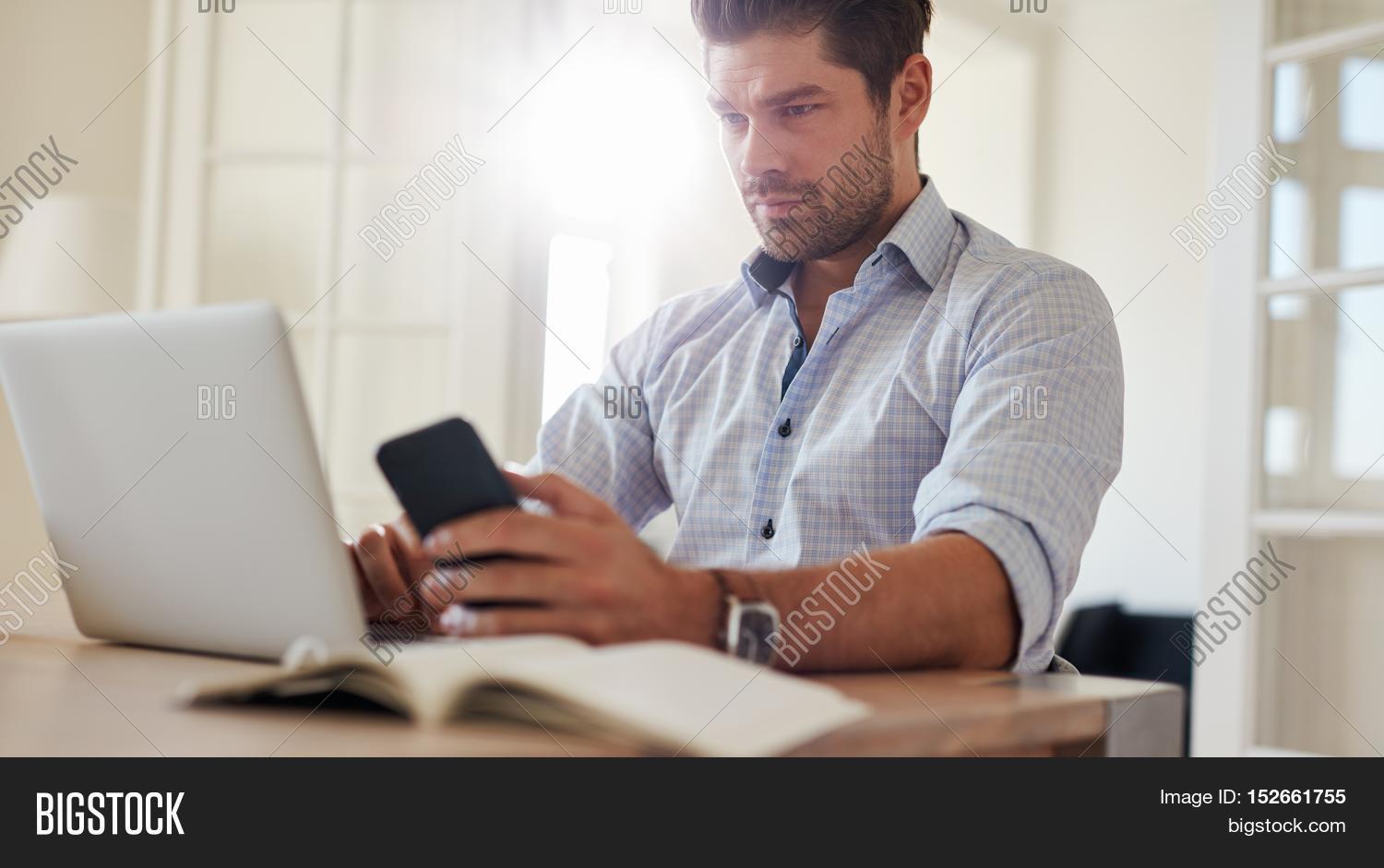 Man Sitting Desk Laptop Mobile Image Photo Stock Man Sitting At Desk With Laptop And Mobile Phone Home